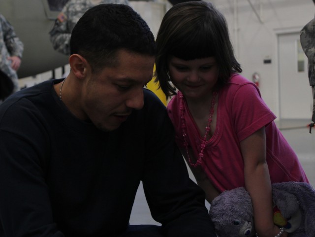 FORT HOOD, Texas - Theo Rossi, from the show "Sons of Anarchy" interacts with Emma Grim, 8, during a meet-and-greet session at one of the 1st Air Cavalry Brigade's hangars, March 9. Kim Coates, one of the show's stars, was also on hand to greet Soldi...
