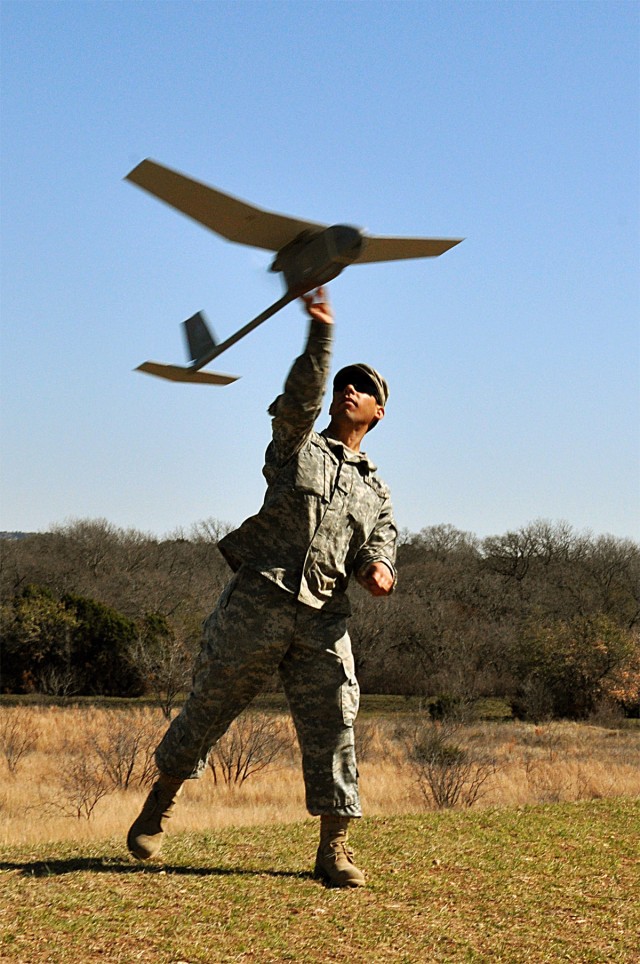 Sgt. John Martinez, tanker with Company D, 1st Battalion, 5th Cavalry Regiment, 2nd Brigade Combat Team, launches the Raven RQ-11B unmanned aerial vehicle in the air during the 41st Fires Bde. and the 2nd BCT re-certification training at the House...