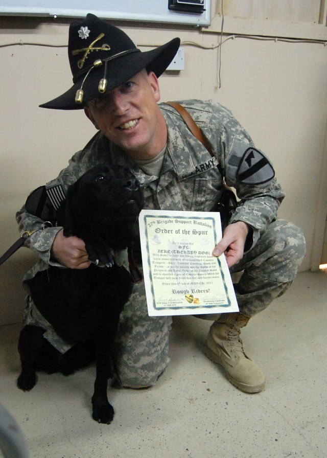 Sgt. 1st Class Jonathan Zeke, a combat stress-relief dog assigned to 85th Medical Combat Stress Control Detachment, is inducted into the Order of the Spur by Lt. Col. Paul Reese, deputy commander of 4th Advise and Assist Brigade, 1st Cavalry...
