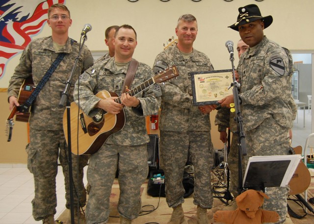 CONTINGENCY OPERATING SITE MAREZ, Iraq - Lt. Col. Monte Rone, a native of Muskegon Heights, Mich., and executive officer of 4th Advise and Assist Brigade, 1st Cavalry Division, presents a certificate of appreciation to 4th Infantry Division rock band...
