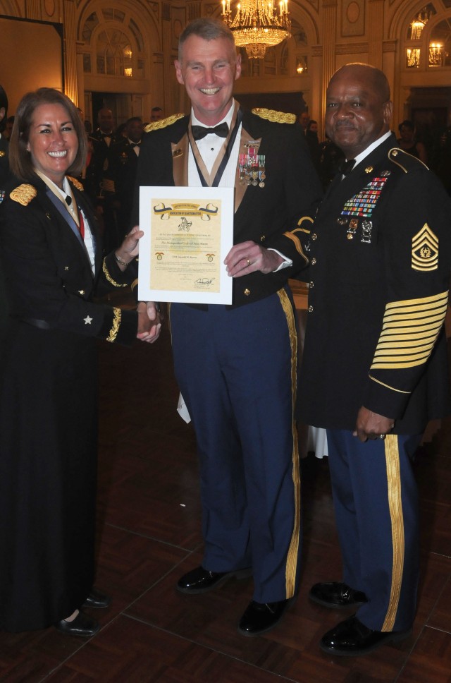 Brig. Gen. Robin Akin, the 3d Sustainment Command (Expeditionary) commander, presents the Order of Saint Martin to Col. Jarrold Reeves, the 3d ESC's deputy commanding officer, during the 60th Anniversary Ball March 24 in Louisville, Ky. The Order...