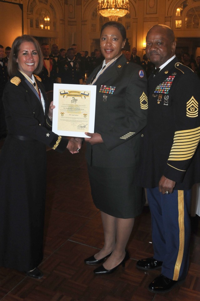 Brig. Gen. Robin Akin, the 3d Sustainment Command (Expeditionary) commander, presents the Order of Saint Martin to Master Sgt. Angel Ladaker during the 60th Anniversary Ball March 24 in Louisville, Ky. The Order of Saint Martin is presented to...