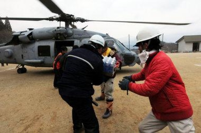 Japenese Citizens Move Food and Water Out of A HH-60H Sea Hawk