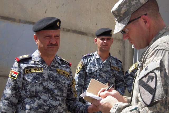 BAGHDAD-Lt. Col. Cameron Cantlon (right), the commander of 6th Squadron, 9th Cavalry Regiment, 2nd Advise and Assist Brigade, 1st Infantry Division, United States Division - Center, takes notes during a discussion, Mar. 24,with Staff Maj. Gen....