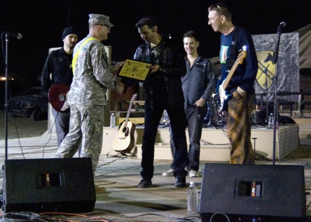 CONTINGENCY OPERATING SITE MAREZ, Iraq - After performing a two hour concert for Soldiers assigned to the 4th Advise and Assist Brigade, 1st Cavalry Division, Lt. Col. Eric Land, commander of the 4th Brigade Special Troops Battalion, presented a cert...
