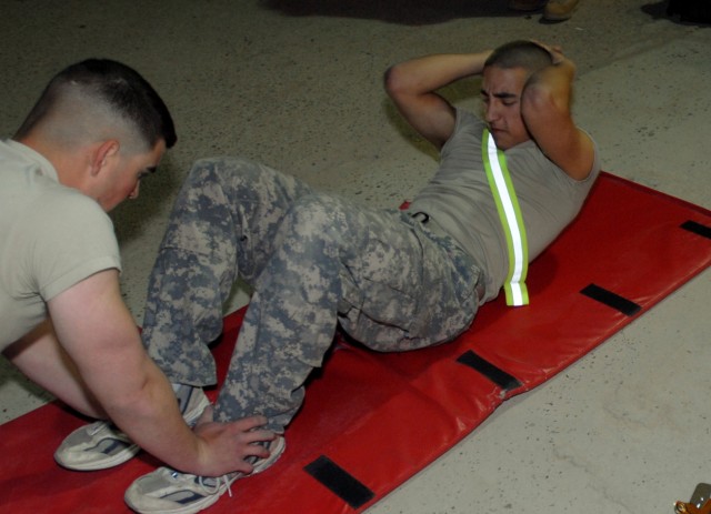 CONTINGENCY OPERATING BASE ADDER, Iraq - Spc. Julian McKinnon, with Headquarters and Headquarters Battery, 2nd Battalion, 82nd Field Artillery Regiment, 3rd Advise and Assist Brigade, conducts the sit-ups portion of an Army physical fitness test...