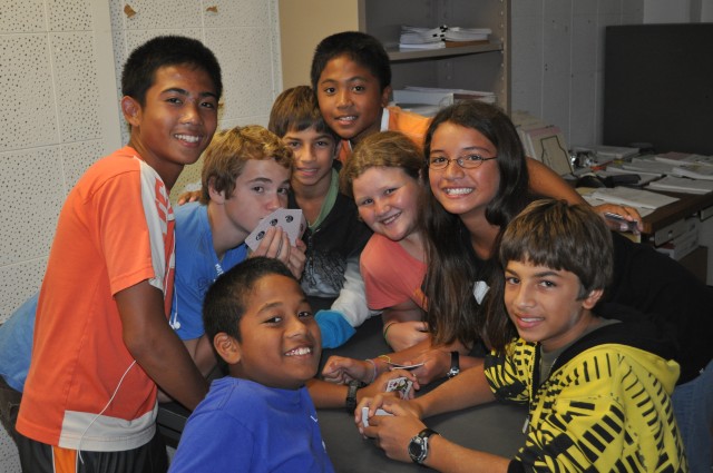 Dave Bonham, left, Auguston Lelet, Sam Jahnke, Eric Tiffany, Dustin Bonham, Allison Hibberts, Colleeen Furgeson and Adam Tiffany make the most of their time in the evacuation shelter March 11 by playing cards and joking with friends in Building...