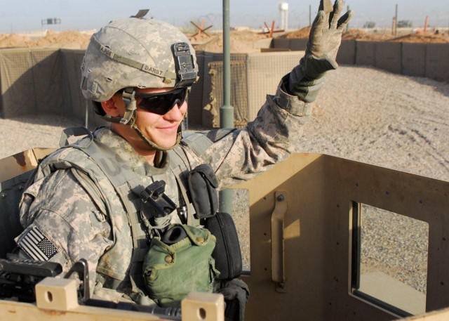 CONTINGENCY OPERATING SITE WARRIOR, Iraq - Spc. Shane Darst, an armor crewmember serving with Company D, 2nd Battalion, 12th Cavalry Regiment, attached to the 1st Advise and Assist Task Force, 1st Infantry Division, waves at a passing patrol near...