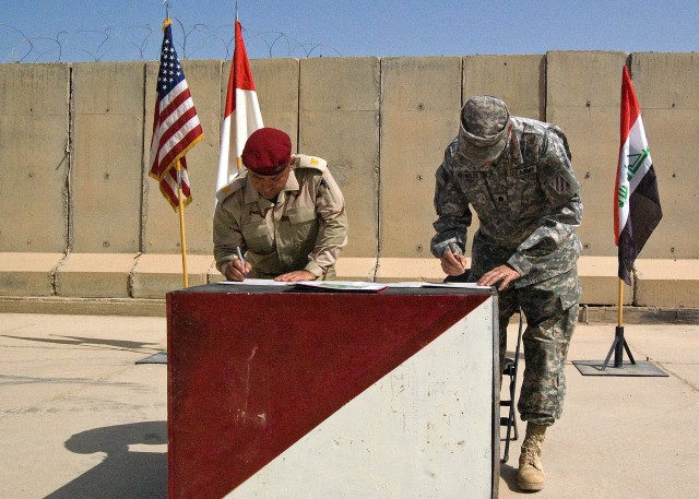 CONTINGENCY OPERATING SITE MAREZ, Iraq - Maj. Mohammad, executive officer of 1st Battalion, 9th Brigade, 3rd Iraqi Army Division,, accepts responsibility for Joint Security Station Heider from Lt. Col. Robert Reynolds, commander, 6th Squadron, 8th Ca...