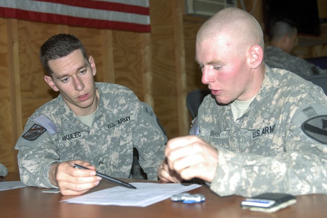 CONTINGENCY OPERATING BASE ADDER, Iraq - Cpl. Brad Mikulec (left), a financial management technician with 9th Financial Management Company, 3rd Sustainment Brigade,  helps Pfc. Emery Barr, a cavalry scout with D Company, 3rd Battalion, 8th Cavalry Re...