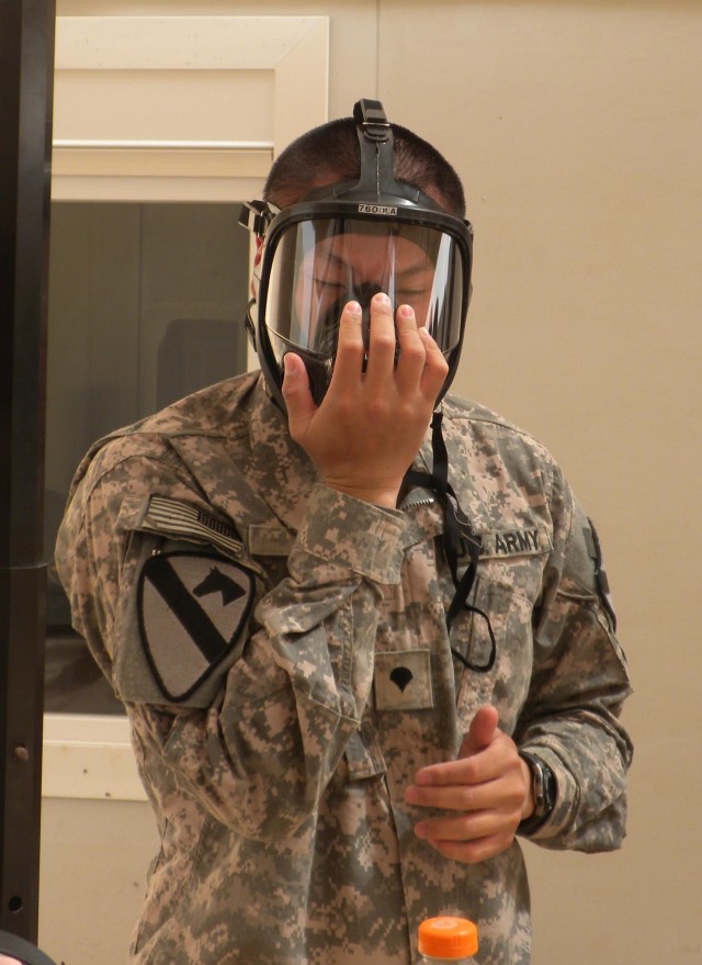 CONTINGENCY OPERATING BASE ADDER, Iraq - Spc. Wei Ni of Charlie Medical Company, 215th Brigade Support Battalion, 3rd Advise and Assist Brigade, 1st Cavalry Division, clears his protective mask at the Hazardous Waste Operations and Emergency Response...
