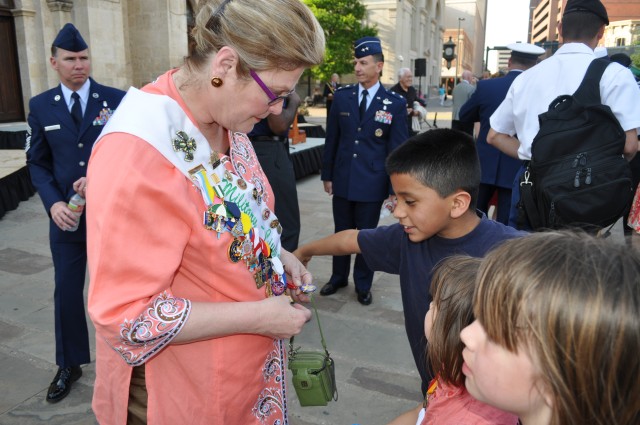 Children admire the Military-Civilian Club representative's sash full of Fiesta medals