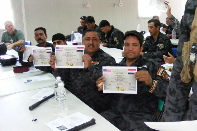 CONTINGENCY OPERATING BASE ADDER, Iraq -Policemen from the Iraqi Police Emergency Response Unit in Maysan Province, Iraq, display their graduation certificates at the completion of riot-control training organized by 3rd Battalion, 8th Cavalry...