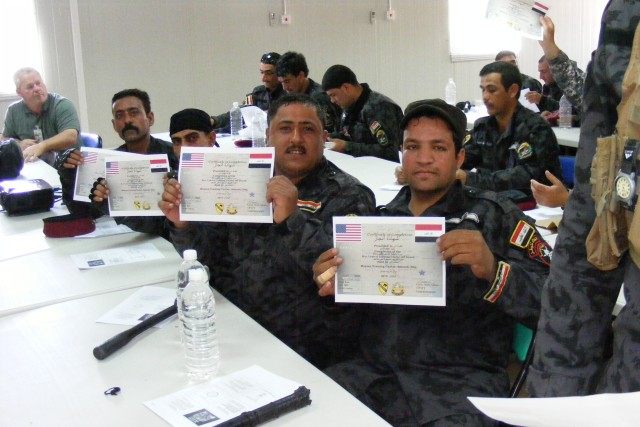 CONTINGENCY OPERATING BASE ADDER, Iraq -Policemen from the Iraqi Police Emergency Response Unit in Maysan Province, Iraq, display their graduation certificates at the completion of riot-control training organized by 3rd Battalion, 8th Cavalry Regimen...