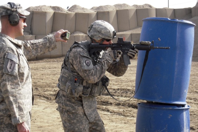 BAGHDAD- Sgt. Norman Bretz, of B Troop, 6th Squadron, 9th Cavalry Regiment, 2nd Advise and Assist Brigade, 1st Infantry Division, United States Division - Center, fires his weapon from behind an obstacle during the "Saber Shooter" competition at the ...