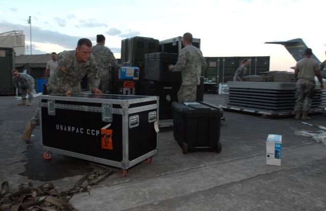 Soldiers unload pallets of equipment