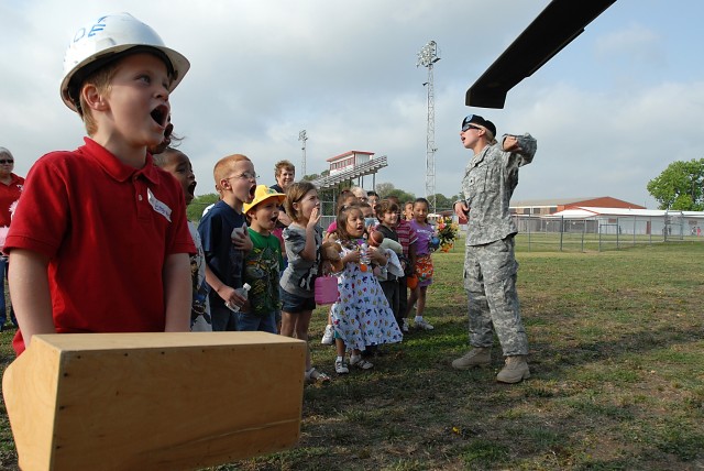 FORT HOOD, Texas-Spc. Melissa Platt (right), a motor pool dispatcher with Company E, Task Force Spearhead, 1st Air Cavalry Brigade, 1st Cavalry Division, from Wausau, Wis., gives a briefing to students from Tyler Elementary School in Belton, Texas...