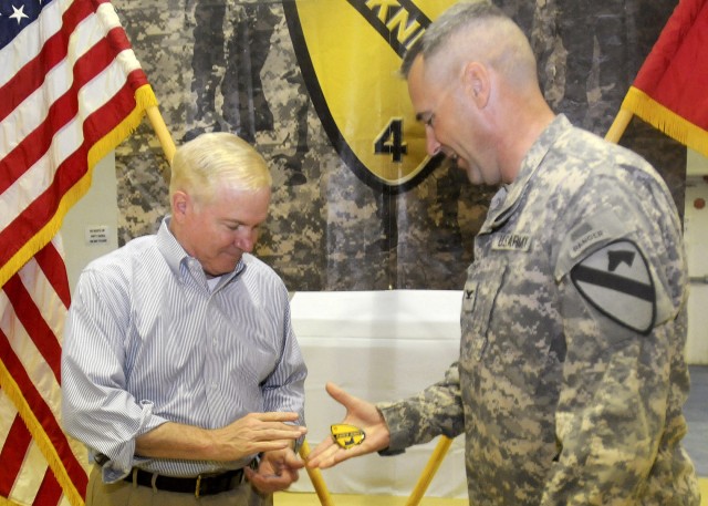 Col. Brian Winski, commander of 4th Advise and Assist Brigade, 1st Cavalry Division, presents Secretary of Defense Robert M. Gates with a "Long Knife" brigade coin for visiting U.S. Soldiers at Contingency Operating Site Marez, April 8, 2011. Gates s...