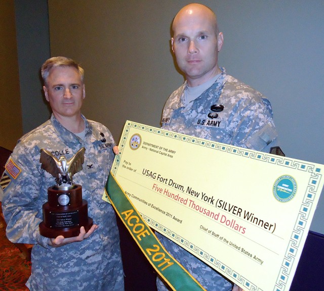 Col Noel T. Nicolle and Command Sgt. Maj. John F. McNeirney hold the garrison's prizes Tuesday after receiving the Army Communities of Excellence silver award in San Antonio. The award gives Fort Drum the distinction of being one of the top places fo...