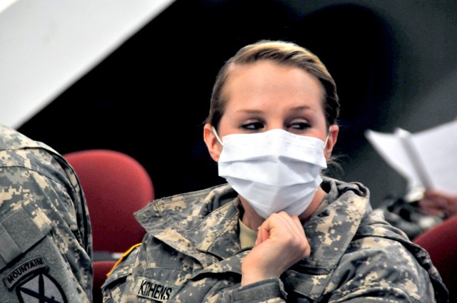 Eighteen-year-old Spc. Kafard Linyah, playacted by Pvt. Shawna Kitchens, 210th Brigade Support Battalion, 2nd Brigade Combat Team, follows other Soldiers to a holding area. Other than her cough, all other signs of the SARS virus -- body aches,...