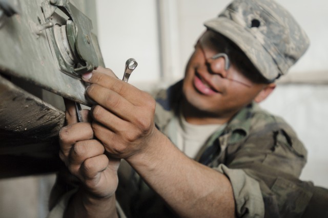 CONTINGENCY OPERATING BASE ADDER, Iraq - Spc. Luis Reyes, a wheeled vehicle mechanic from Dallas with B Field Maintenance Company, 215th Brigade Support Battalion, 3rd Advise and Assist Brigade, 1st Cavalry Division, removes the plate from an interfa...
