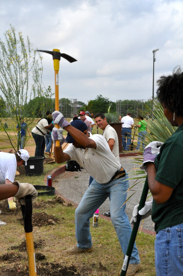 A volunteer clears a hole for a new tree at John James Park during Earth Day.