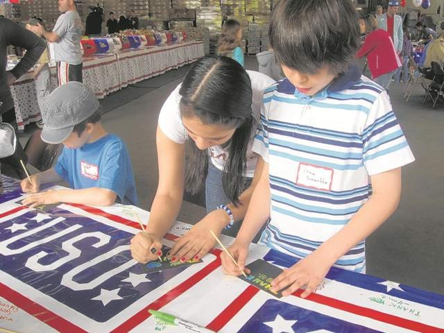 USO and kids team up to stuff packages for troops