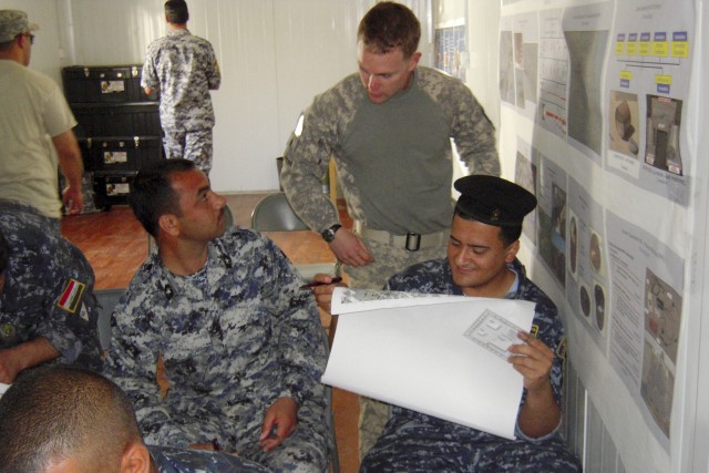BAGHDAD-1st Lt.  Aaron Guaderrama, a platoon leader with B Troop, 6th "Saber" Squadron, 9th Cavalry Regiment, 2nd Advise and Assist Brigade, 1st Infantry Division, United States Division - Center, explains aspects of map reading to a member of 1st Me...