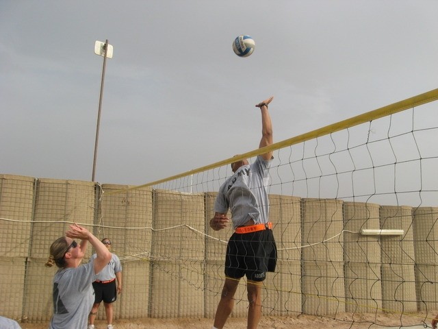 Contingency Operating Base Basrah, Iraq - Pfc. Brandon Combs prepares to execute a spike on Spc. Christina Henderson during the volleyball portion of the Alpha Distribution Company, 215th Brigade Support Battalion, 3rd Brigade Combat Team, 1st...