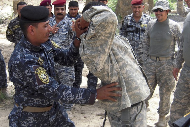 BAGHDAD— A Soldier of the 1st Mechanized Brigade, 4th Federal Police Division practices how to do a personnel inspection on Staff Sgt. Cedric Wilson of Bandit Troop, 6th "Saber" Squadron, 9th Cavalry Regiment, 2nd Advise and Assist Brigade, 1st...
