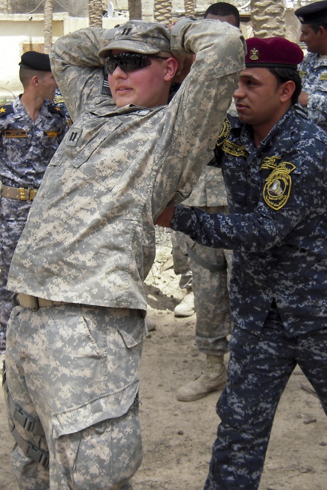 BAGHDAD— A Soldier of the 1st Mechanized Brigade, 4th Federal Police Division practices how to do a personnel inspection on Cpt. David Hanna of Bandit Troop, 6th "Saber" Squadron, 9th Cavalry Regiment, 2nd Advise and Assist Brigade, 1st Infantry...