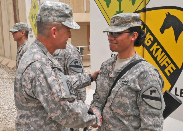 CONTINGENCY OPERATING SITE MAREZ, Iraq - Maj. Gen. Daniel Allyn, commanding general of 1st Cavalry Division, awards Spc. Charis Leatigaga, an administrative clerk assigned to Headquarters and Headquarters Company, 4th Advise and Assist Brigade, 1st C...