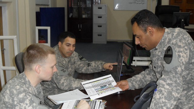 BASRAH, Iraq - Spc. Ehab Amir, 09L Linguist for the Basrah Operations Command Team, and Sgt. Cohen Kanewske, noncommisioned officer in charge, cover the 12-hour day shift coordinating Joint Iraqi escorts for United States Forces-Iraq missions and...