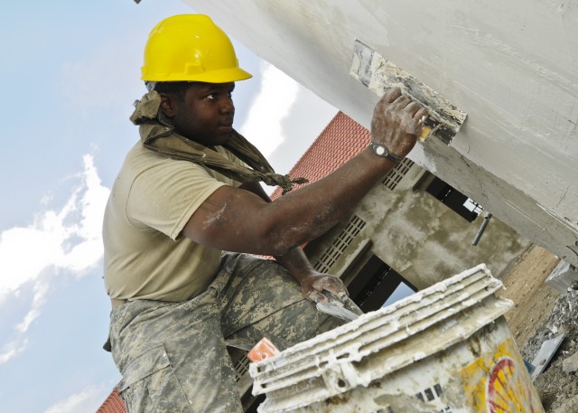 Soldier applies plaster to latrine