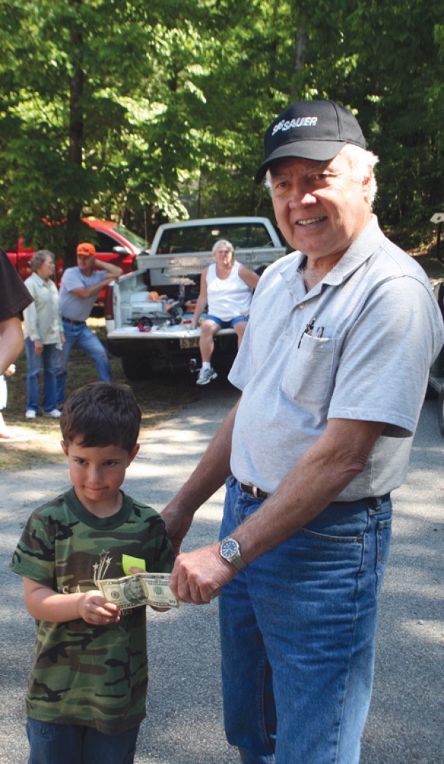 Charlie Lewis, right, gives Sebastian Melendez, age 5,  a $50 prize for catching the most fish in the tournament. 
