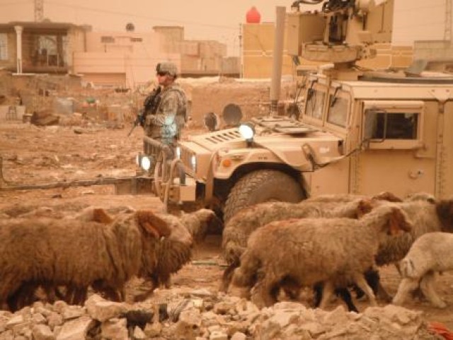 Soldier ground guides Humvee in Iraq