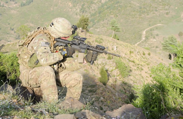 Cav. Scout checks sights while on patrol in Afghanistan