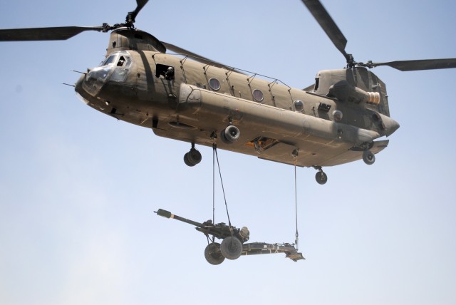 Howitzer slung under a Chinook helicopter