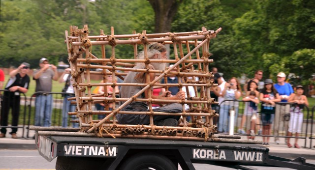 A man sits in a tiger cage during Rolling Thunder