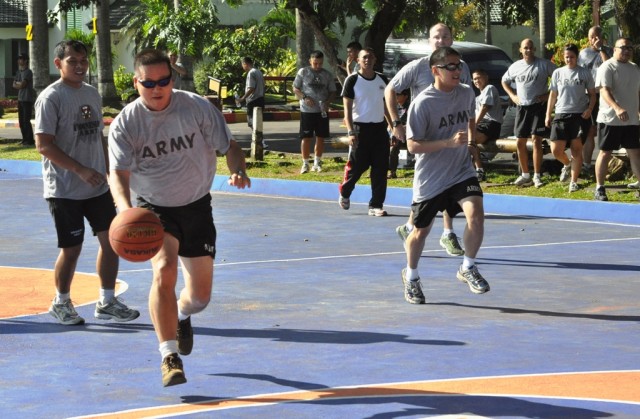 U.S. Army and Indonesian Armed Forces Soldiers run toward a basketball hoop