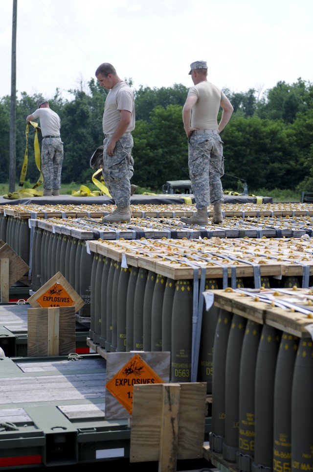 Soldiers with the 1055th Transportation Company handle artillery rounds