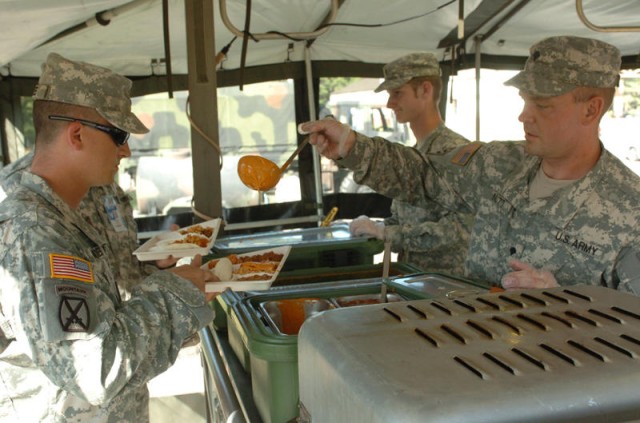 Army cooks prepare meals in the field