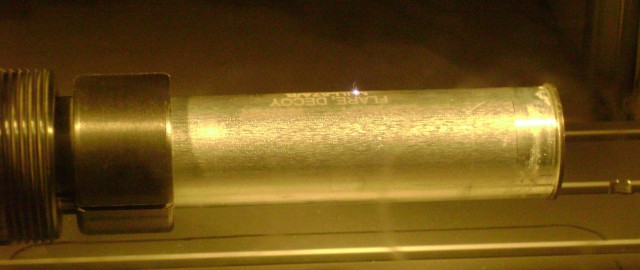 A close-up of the laser etcher beam at work on a decoy flare