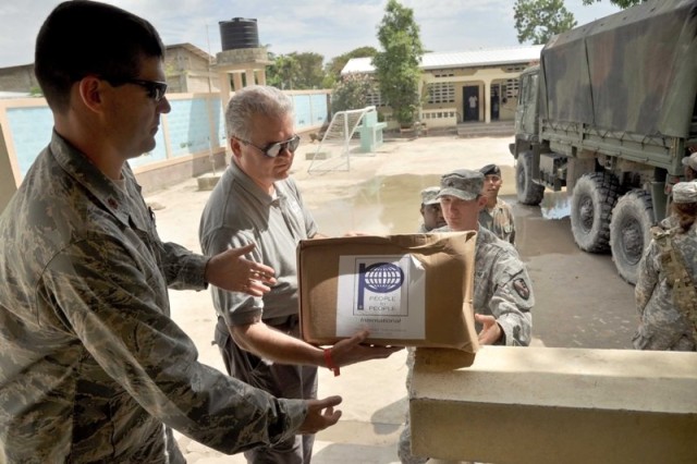 PTPI chairman and Sgt. Cailouet hand out donated school supplies