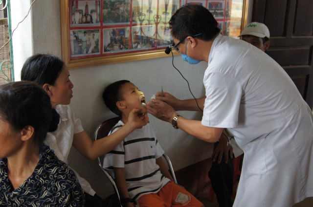 Vietnamese army doctor examines child