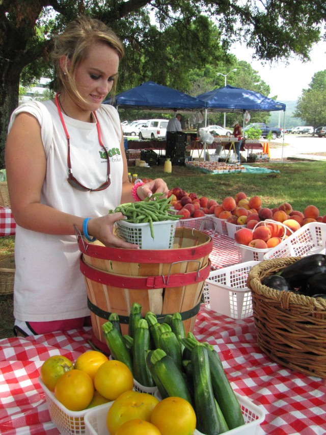 Kayla Beasley Of Isoms Orchard Sets Up Vegetables For Display