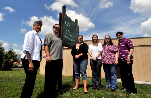 Judy Munoz, from left, EEO specialist, Barry DuBois, EEO officer, and Angela Jones, EEO complaints manager, stand outside their office Friday alongside three college students with disabilities who are working on the installation this summer as...