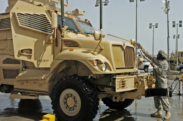 Soldier in Kuwait washing MRAP redeployed from Iraq