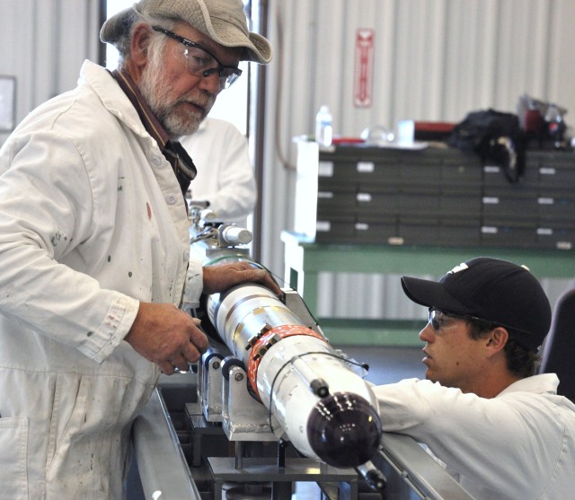 Ammunition Operations employees from Tooele Army Deot, TJ Robinson and Jake Mitchell, assist the NAVY's specialized Rolling Airframe Missile (RAM) ceretification process.