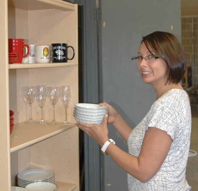 Nina Wilson, the 177th Armored Brigade family readiness support assistant, sorts dishes at the lending closet she created. The lending closet is supported by donations within the brigade and items are